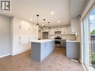 Binbrook apartment for rent - A spacious kitchen with white cabinets and a central island.