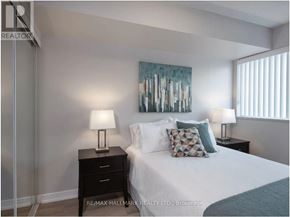 Toronto (Bay Street Corridor) condo for rent - A bedroom with a bed, two lamps, and a painting on the wall.