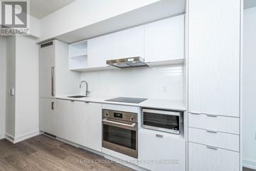 Toronto (Waterfront Communities) condo for rent - A modern kitchen with white cabinets and stainless steel appliances.
