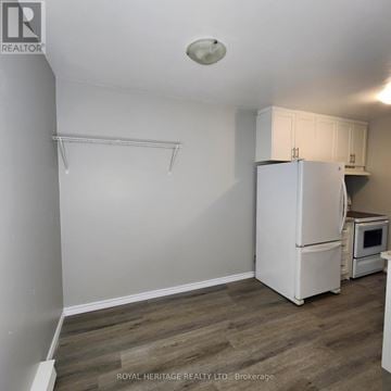 Oshawa (Pinecrest) townhouse for rent - A white refrigerator in a kitchen with wooden flooring.