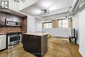 Toronto (South Riverdale) condo for rent - A kitchen with a brick wall and stainless steel appliances.