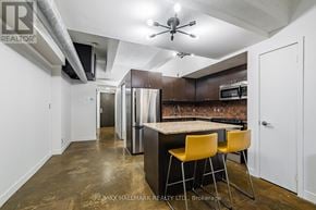 Toronto (South Riverdale) condo for rent - A kitchen with a bar stool and a counter.