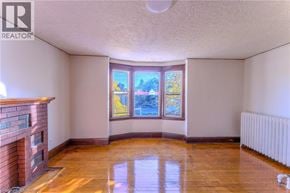 Hamilton apartment for rent - A room with a fireplace and a window with a view of trees.