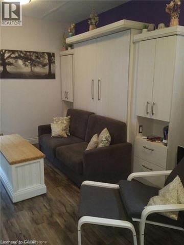 Hamilton apartment for rent - A living room with a brown couch, a wooden table, and a painting on the wall.