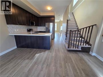 Hamilton townhouse for rent - A kitchen with a stove top oven and a staircase.