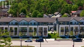 Orillia townhouse for rent - A row of modern houses with a car parked in front.