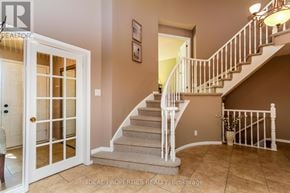 Ottawa apartment for rent - A staircase with a white railing and beige carpeted steps leads to a second floor.