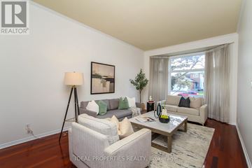 Ottawa apartment for rent - A well-lit living room with a grey couch and a wooden floor.