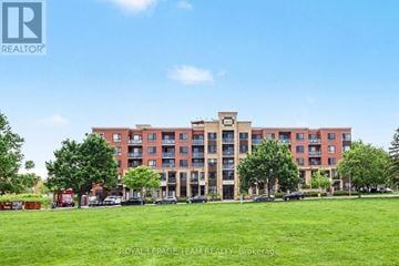 Ottawa condo for rent - A large red brick building with a green lawn in front.