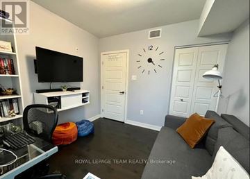 Ottawa condo for rent - A living room with a grey couch and a black television.