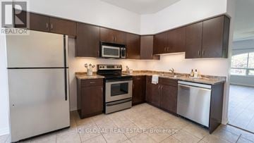 Burlington (Appleby) townhouse for rent - A kitchen with brown cabinets and stainless steel appliances.