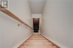 Cambridge townhouse for rent - A hallway with wooden stairs leading to a door at the end.