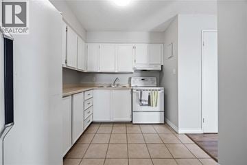 Sarnia condo for rent - A kitchen with white cabinets and a dishwasher.
