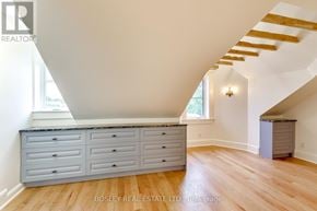 Toronto (Dufferin Grove) fourplex for rent - A room with a large window, wooden floors, and a grey cabinet with drawers.