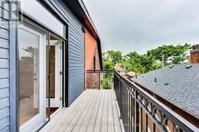 Toronto (Dufferin Grove) fourplex for rent - A balcony with a railing and a view of the backyard.