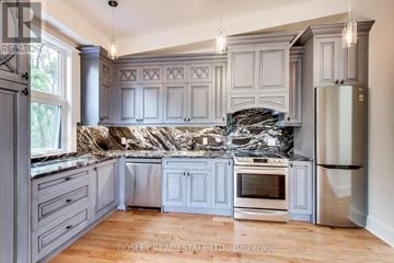 Toronto (Dufferin Grove) fourplex for rent - A kitchen with a granite countertop and stainless steel appliances.