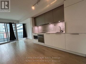 Toronto (Church-Yonge Corridor) condo for rent - A modern kitchen with white cabinets and a wooden floor.