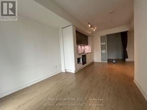 Toronto (Church-Yonge Corridor) condo for rent - A spacious room with wooden flooring and white walls, featuring a kitchenette with a refrigerator, microwave, and oven.