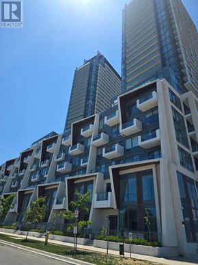 Toronto (Newtonbrook East) condo for rent - A modern building with a unique design stands tall against a clear sky.