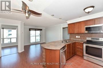 Toronto (Clanton Park) condo for rent - A kitchen with wooden cabinets and a fan on the ceiling.