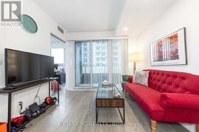 Toronto (Niagara) condo for rent - A living room with a red couch and a flat screen TV.