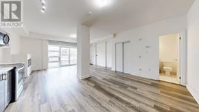 Toronto (Willowdale West) townhouse for rent - A spacious, well-lit kitchen and living room with hardwood floors and white walls.
