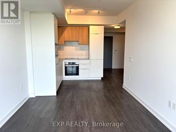 Toronto (Banbury-Don Mills) condo for rent - A kitchen with white cabinets and a wooden backsplash.