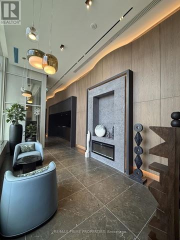 Pickering (Bay Ridges) condo for rent - A modern living room with a grey sofa and a fireplace.