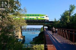 Toronto (Rouge) apartment for rent - A green and white train is crossing a bridge over a river.