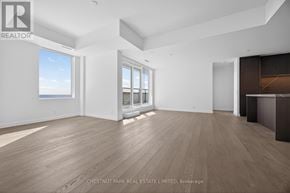 Toronto (Greenwood-Coxwell) condo for rent - A spacious room with wooden flooring and a large window overlooking the beach.