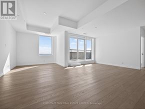 Toronto (Greenwood-Coxwell) condo for rent - A spacious room with wood flooring and large windows.