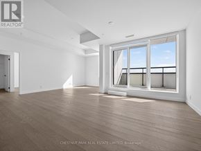 Toronto (Greenwood-Coxwell) condo for rent - A room with a large window and wooden flooring.