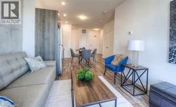 Waterloo condo for rent - A living room with a grey couch, a wooden coffee table, and a blue chair.