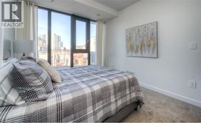 Waterloo condo for rent - A bedroom with a large bed and a painting on the wall.