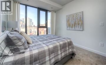 Waterloo condo for rent - A bedroom with a large bed and a painting on the wall.