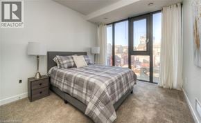 Waterloo condo for rent - A bedroom with a large bed and a view of the city.