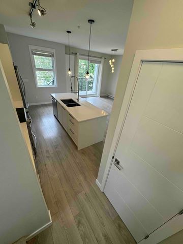 Port Coquitlam apartment for rent - A kitchen with a white counter top and wooden floors.