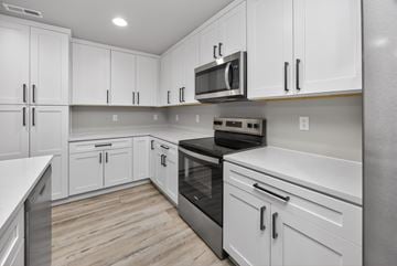 Urbandale apartment for rent - A kitchen with white cabinets and stainless steel appliances.