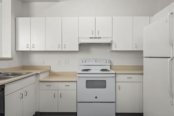 Yakima apartment for rent - A white kitchen with a stove and cabinets.