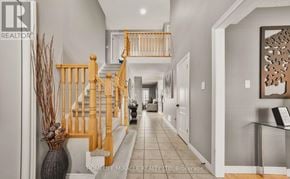 Amaranth apartment for rent - A hallway with a wooden staircase and a glass table.