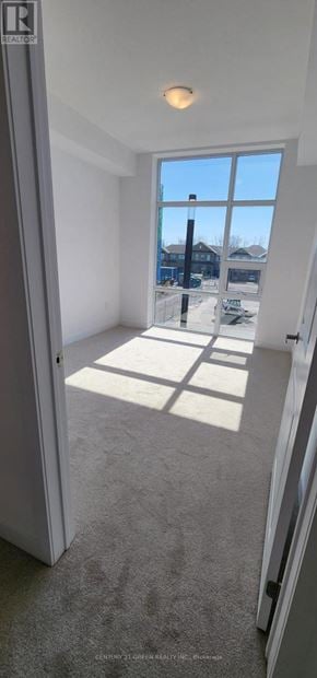 Hamilton (Waterdown) condo for rent - A room with a large window and a view of a building outside.