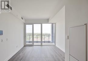 Mississauga (Port Credit) condo for rent - A spacious room with a view of the outdoors through large windows.