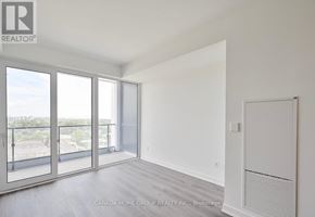 Mississauga (Port Credit) condo for rent - A spacious room with a view of the city through large windows.