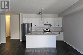 Cambridge townhouse for rent - A kitchen with white cabinets and a stainless steel refrigerator.