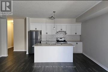 Cambridge townhouse for rent - A kitchen with white cabinets and a stainless steel refrigerator.