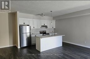 Cambridge townhouse for rent - A kitchen with white cabinets and a stainless steel refrigerator.