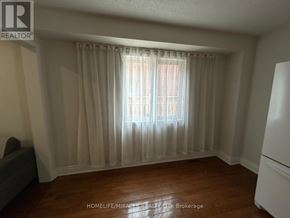 Brampton (Fletcher's West) apartment for rent - A room with a window covered by curtains and a wooden floor.