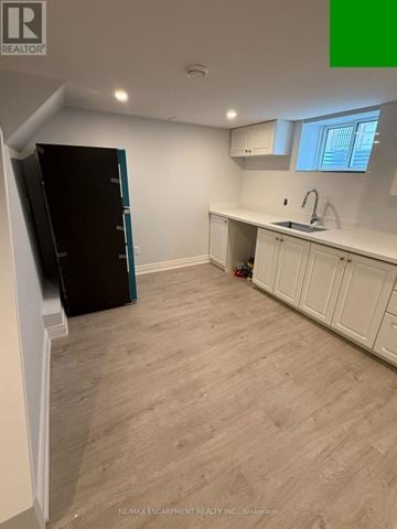 St. Catharines (Bunting/Linwell) apartment for rent - A kitchen with white cabinets and a wooden floor.