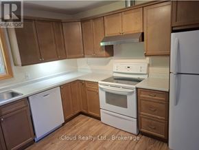 Owen Sound apartment for rent - A kitchen with wooden cabinets and white appliances.