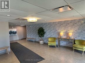 Guelph (Grange Road) condo for rent - A waiting area with a bench, two chairs, and a table with lamps.